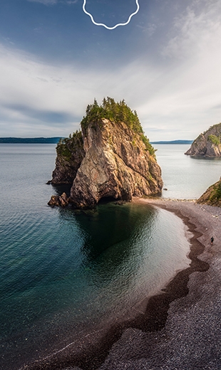 A massive rock formation rests at a beach in Chance Cove.