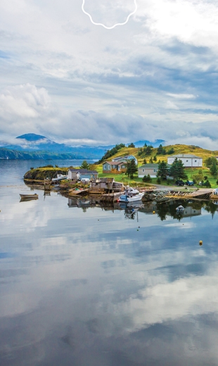 The town of Little Harbour East reflects in the water of the harbour.