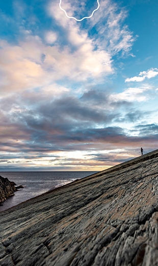 A traveller explores the ancient fossil platform at Mistaken Point.