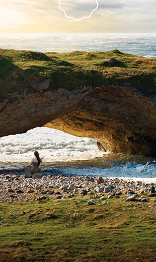 A traveller listens to the ocean waves rushing in through The Arches. 