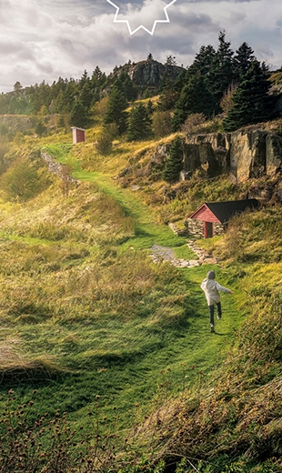 A boy runs toward the sunrise and a red shed in Bay Roberts. 