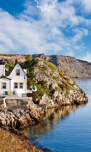 A person is drying a towel from their little house on the coastline in Brigus.