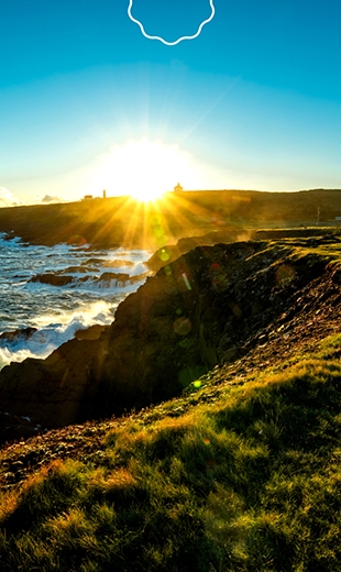 The sun rises over the coastline in Cape Spear.