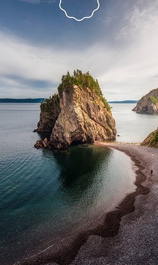 A massive rock formation rests at a beach in Chance Cove.