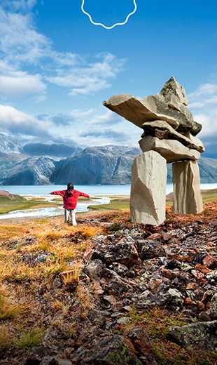 A child is surrounded by the beauty of the Torngat Mountains.